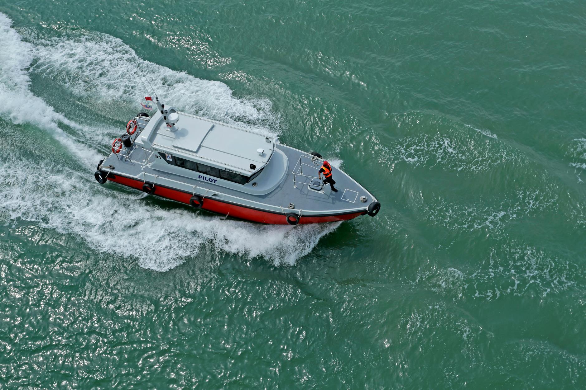 Dynamic aerial shot of a pilot boat cutting through the sea waves.