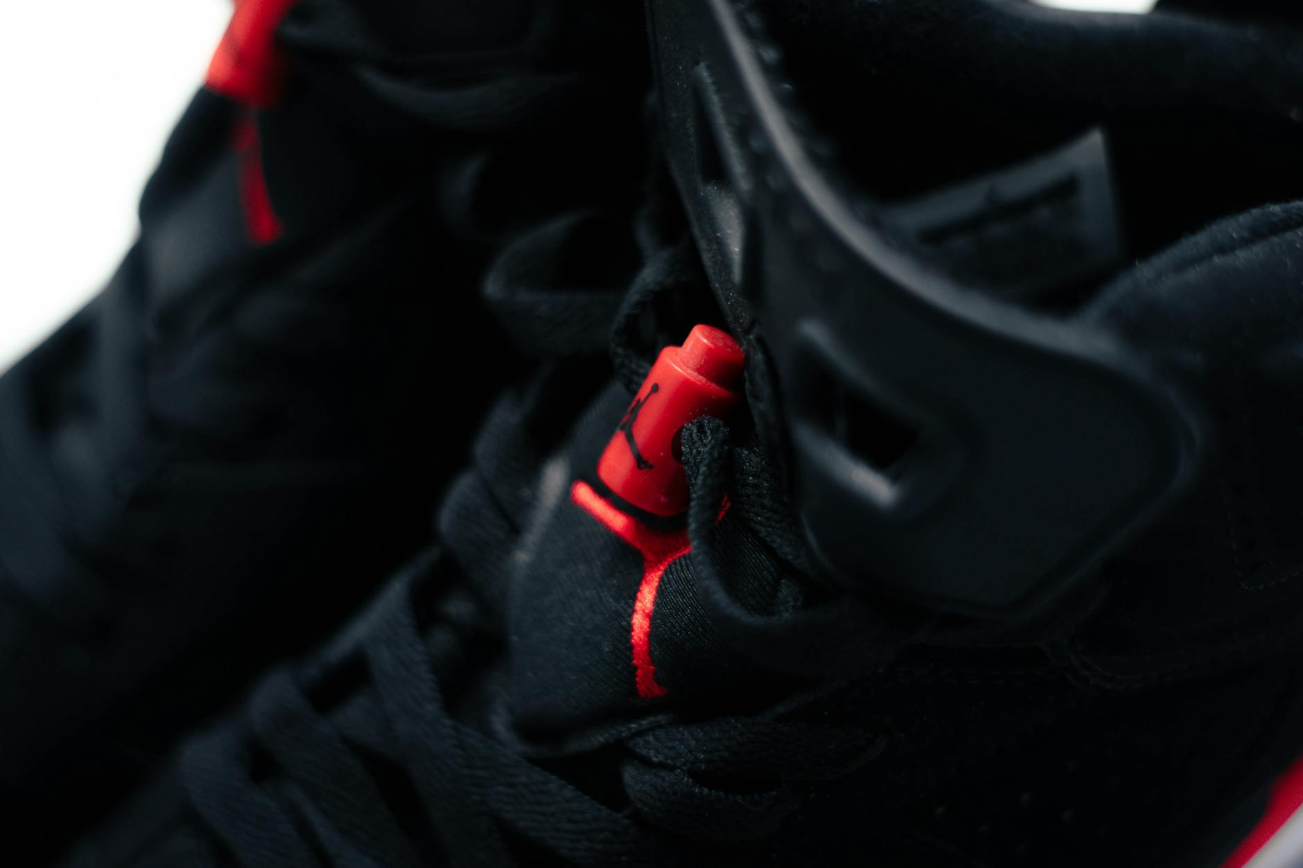 Detailed close-up of black sneakers with red accents showcasing modern design and fashion appeal.